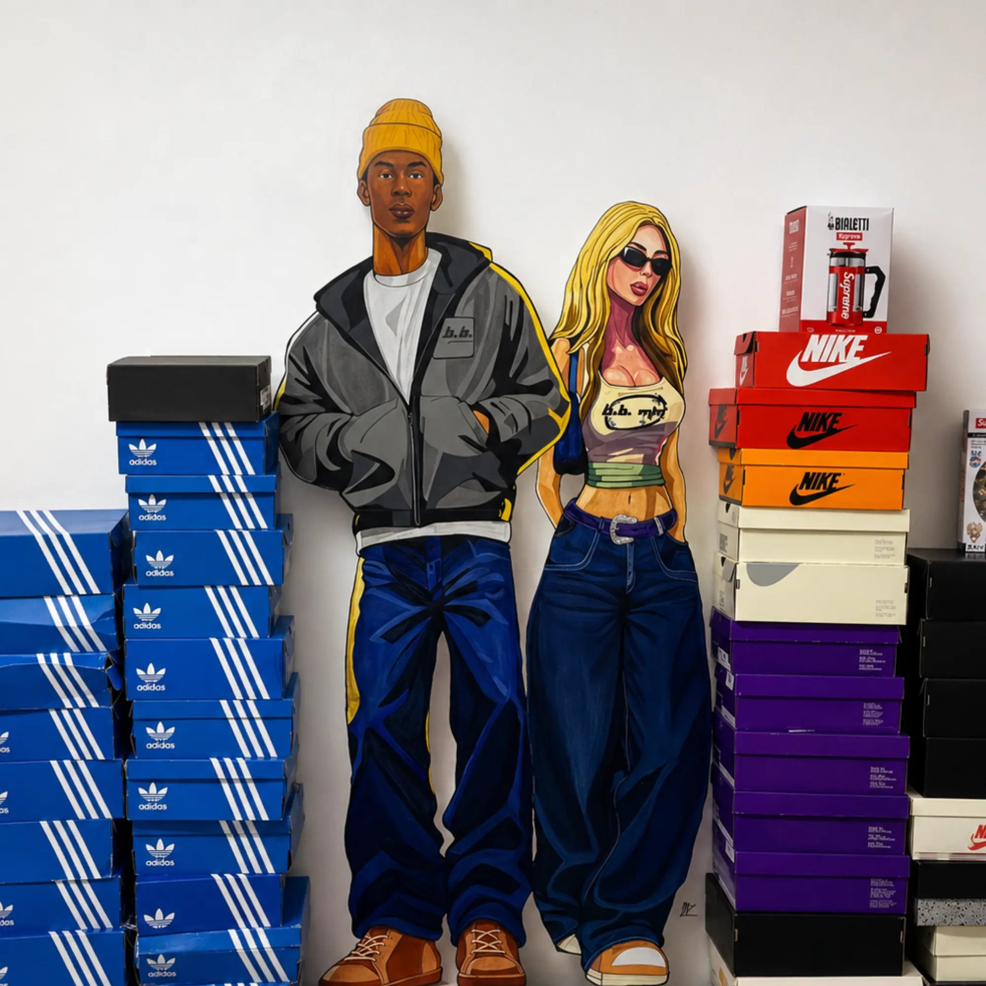 Two people standing between stacks of Adidas and Nike shoe boxes.